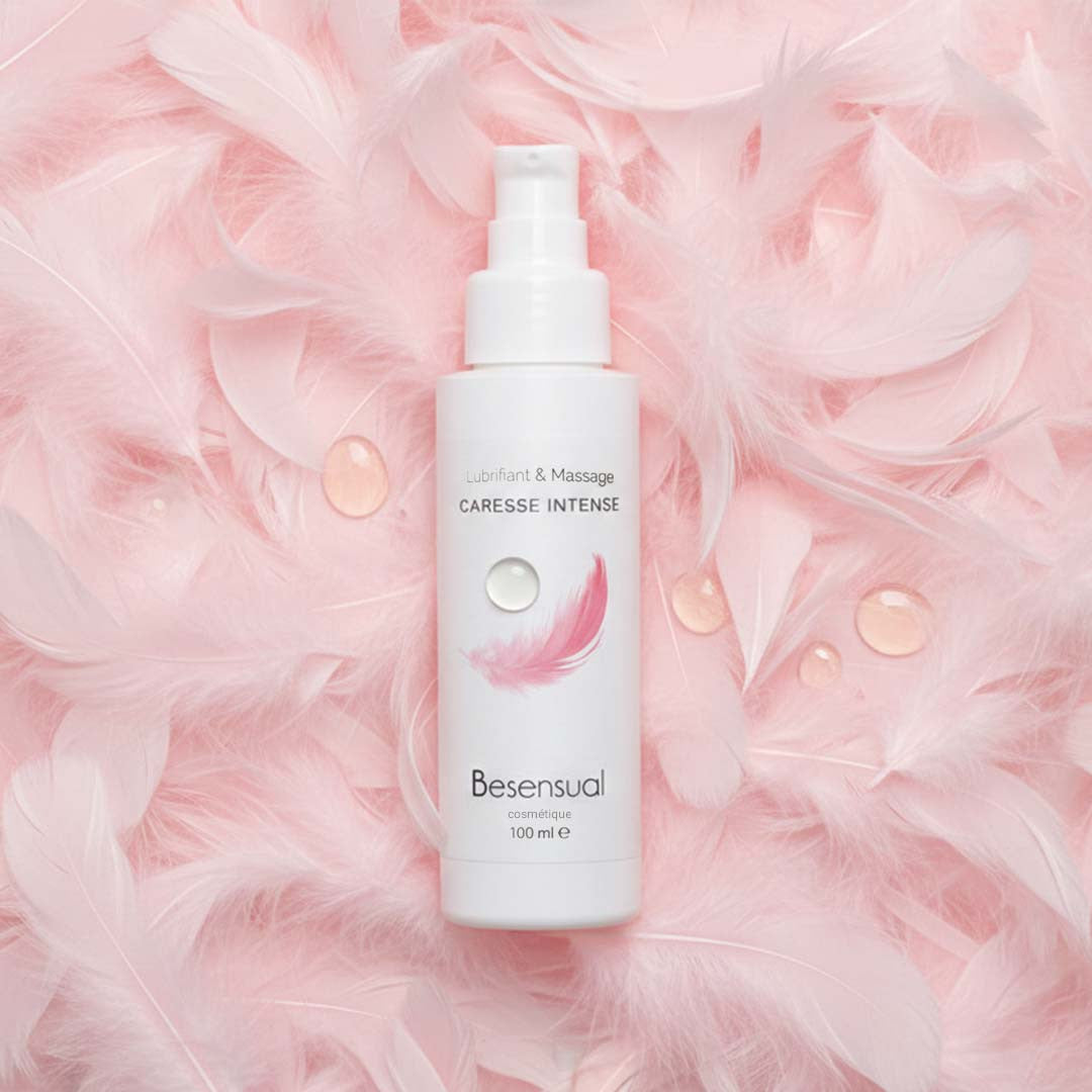 Be Sensual Huile Siliconée Lubrifiant & Massage Neutre Caresse 100 mL Flacon Vue de Face sur lit de plume