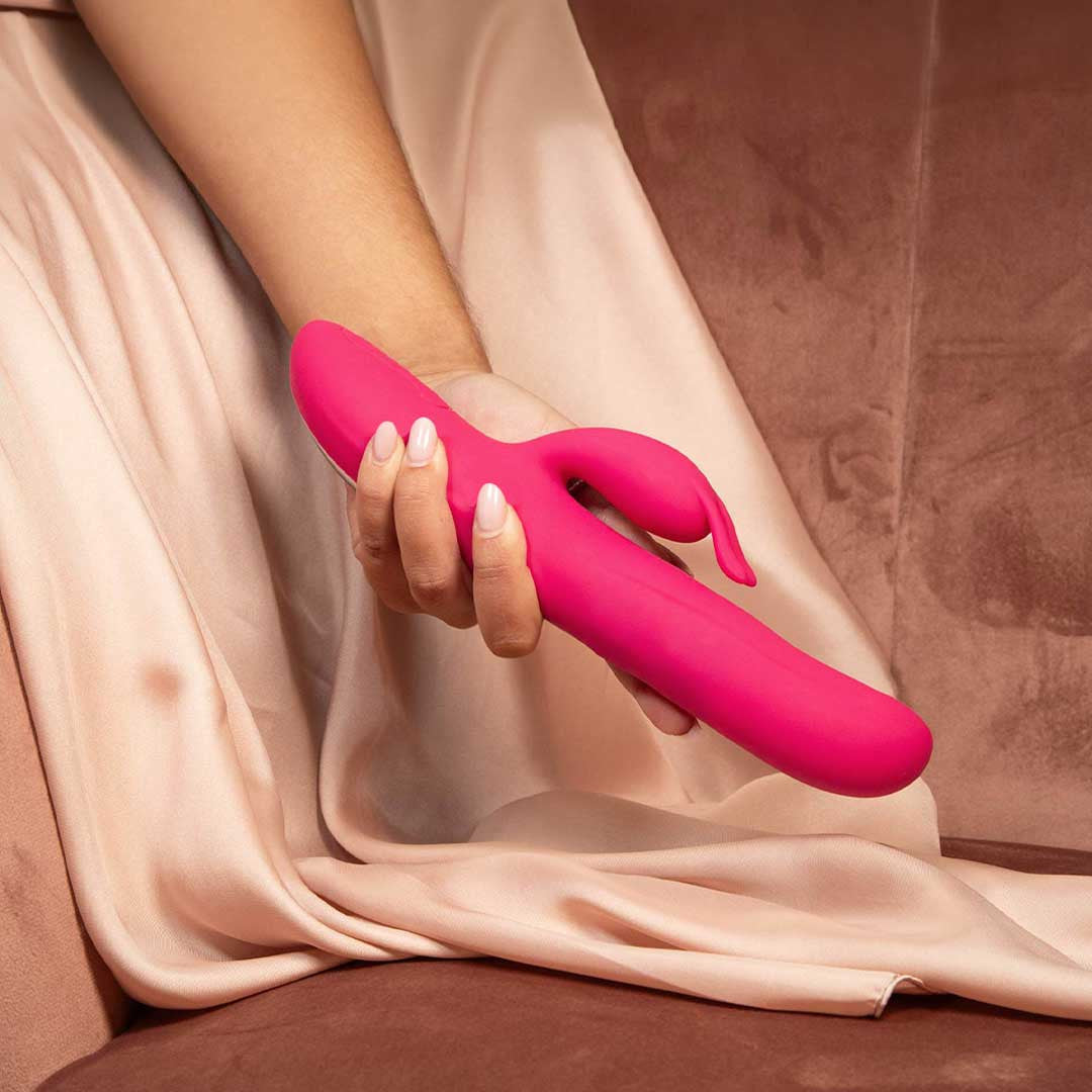 femme qui tient en main un sextoy rabbit rose