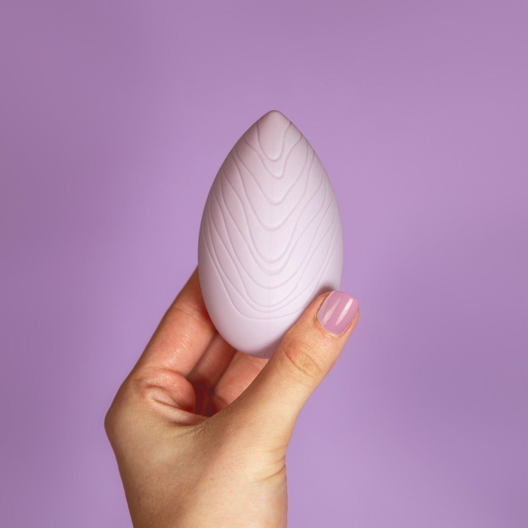 sextoy clitoridien reverence galet silicone lila tenu en main